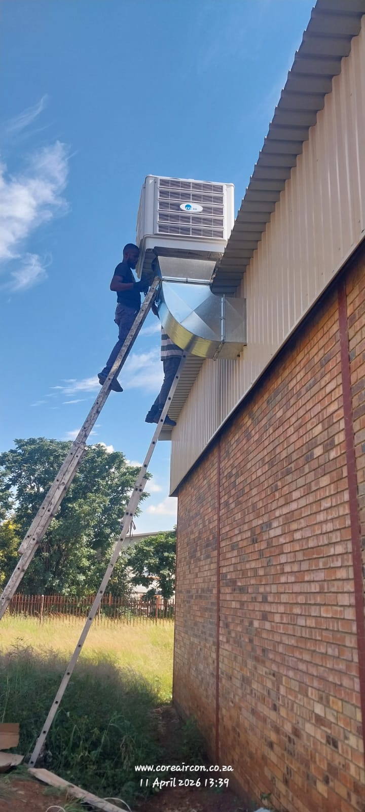 Evaporative cooling unit installation on a warehouse roof